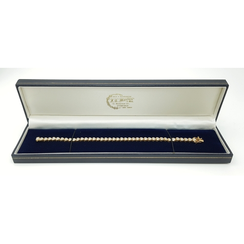 11 - An 18K Yellow Gold Diamond Tennis Bracelet in Heart-Shaped Links. Over 100 round brilliant cut diamo... 