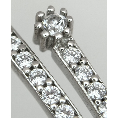 554 - A 14K White Gold and Diamond Crossover Bangle Bracelet. c.100 micro-claw pave set diamonds of c.1ctw... 