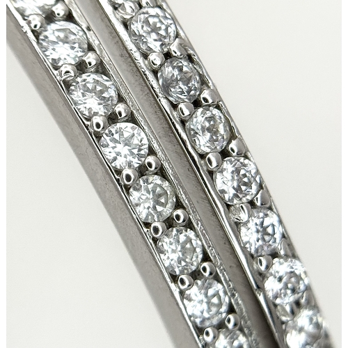 554 - A 14K White Gold and Diamond Crossover Bangle Bracelet. c.100 micro-claw pave set diamonds of c.1ctw... 