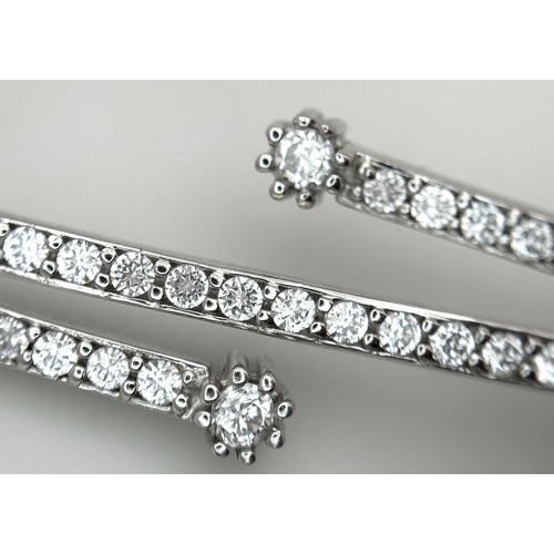 554 - A 14K White Gold and Diamond Crossover Bangle Bracelet. c.100 micro-claw pave set diamonds of c.1ctw... 