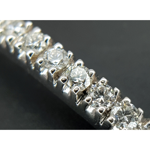 568 - An 18K White Gold (tests as) and Diamond Wave Bangle. 0.87ctw or round brilliant cut diamonds in a m... 