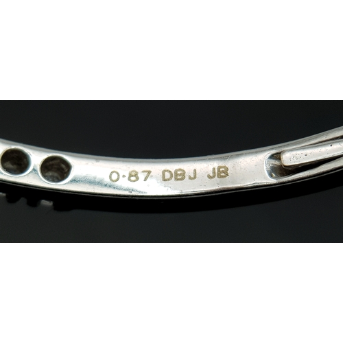 568 - An 18K White Gold (tests as) and Diamond Wave Bangle. 0.87ctw or round brilliant cut diamonds in a m... 