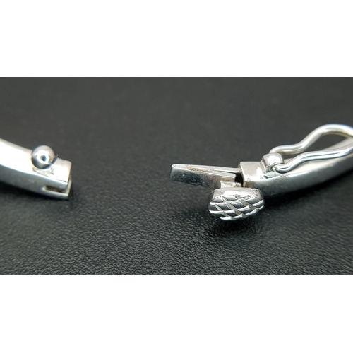 568 - An 18K White Gold (tests as) and Diamond Wave Bangle. 0.87ctw or round brilliant cut diamonds in a m... 