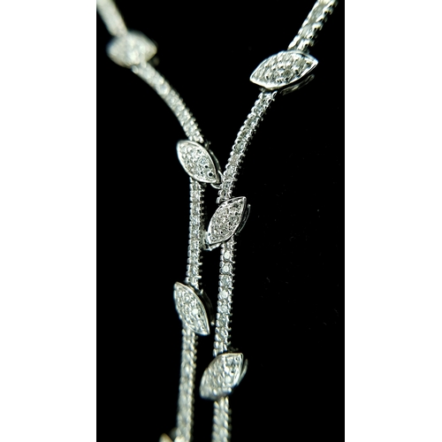 78 - An 18K White Gold and Diamond Y-Drop Necklace Featuring a Continuous String of Leaf-Shaped Motifs. T... 