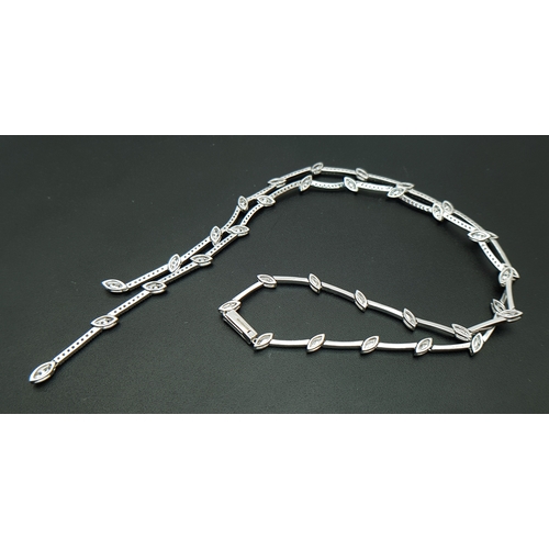 78 - An 18K White Gold and Diamond Y-Drop Necklace Featuring a Continuous String of Leaf-Shaped Motifs. T... 