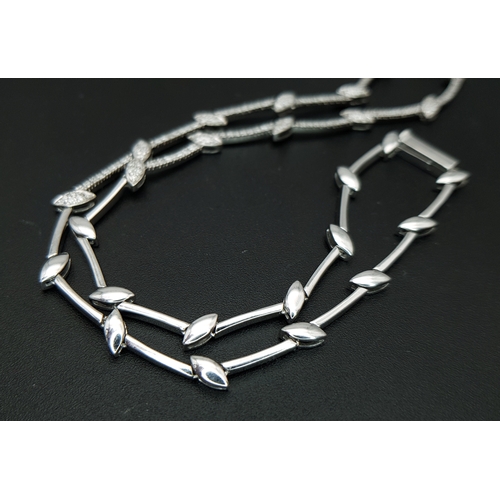78 - An 18K White Gold and Diamond Y-Drop Necklace Featuring a Continuous String of Leaf-Shaped Motifs. T... 