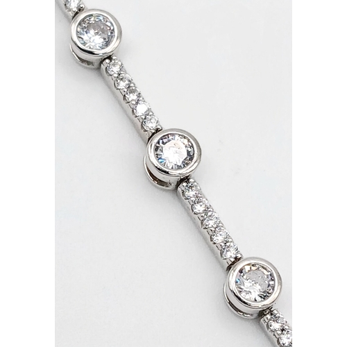 578 - A Pretty Sterling Silver Cubic Zirconia Tennis Bracelet-19.5cm Length. 4mm wide and set with two siz... 