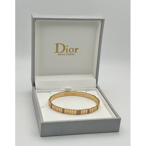 12 - A Dior 18K rose gold and diamond bangle. Total weight 19.676G. Measure: 6cmx4cm. Comes with card of ... 
