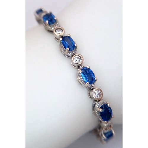 592 - A Beautiful Sterling Silver Blue and White Topaz Tennis Bracelet-19cm Length. Set with 6 x 4mm Oval ... 