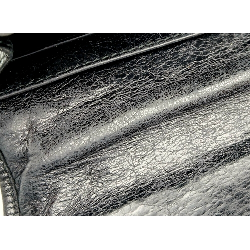579 - A Miu Miu Nappa Matelassé Flap Wallet. Black matelassé pleated leather exterior with silver-toned lo... 