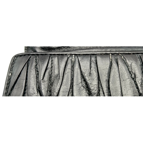 579 - A Miu Miu Nappa Matelassé Flap Wallet. Black matelassé pleated leather exterior with silver-toned lo... 