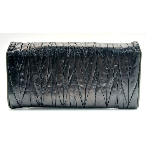 579 - A Miu Miu Nappa Matelassé Flap Wallet. Black matelassé pleated leather exterior with silver-toned lo... 