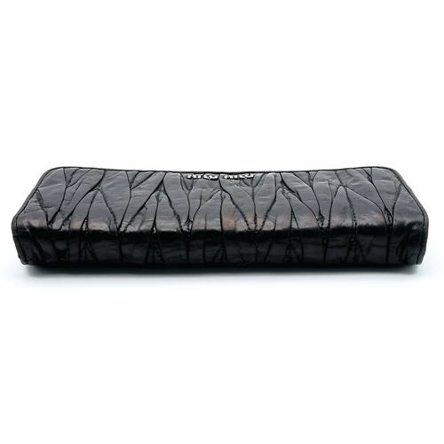 579 - A Miu Miu Nappa Matelassé Flap Wallet. Black matelassé pleated leather exterior with silver-toned lo... 