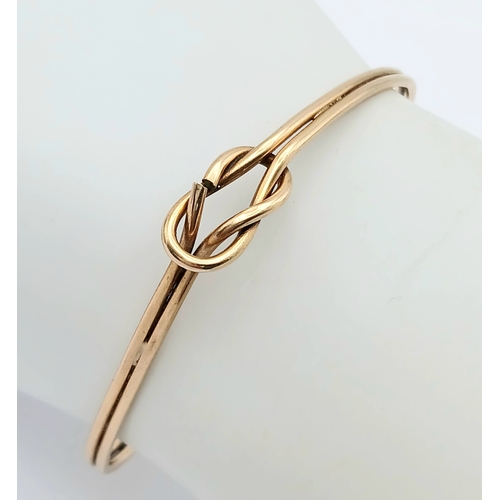 61 - A 9K Yellow Gold Bangle Bracelet. Twin row knot design. 55mm inner diameter. 7.7g.