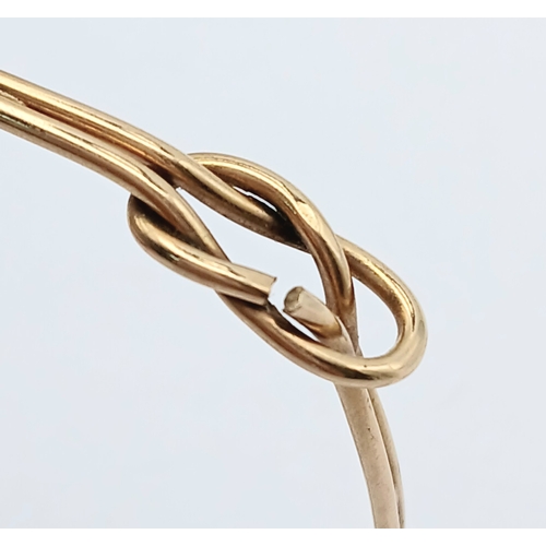 61 - A 9K Yellow Gold Bangle Bracelet. Twin row knot design. 55mm inner diameter. 7.7g.