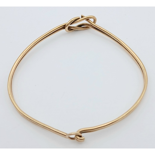 61 - A 9K Yellow Gold Bangle Bracelet. Twin row knot design. 55mm inner diameter. 7.7g.