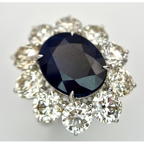 A Stunning 18K White Gold Sapphire and Diamond Ring. An oval cut 7.37ct high-grade sapphire with a round brilliant cut ten diamond surround of 7.12ctw. G-H colour with VS2 clarity. Comes with a certificate. Size L 1/2. 8.75g total weight. TB116.