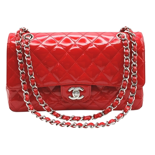 A Chanel Red Patent Leather Classic Double Flap Bag. Red leather exterior with silver-toned hardware, chain shoulder strap and CC turn-lock closure. Features one zipped pocket under the flap. Red leather interior with one main compartment, two open side pockets and a front pocket. Approx 25cm length x 15cm height x 6cm depth. Comes with a Chanel authenticity card and authentication paperwork. Some scratches, stains, signs of wear to the leather. Please see photos or request a condition report. Ref: 28726.