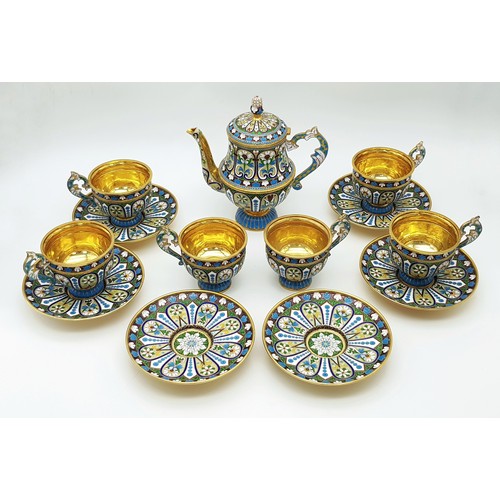 A Large Russian Style Enamelled Silver Gilt Tea Set. Comprising: one tea pot (approx 18cm height), six tea cups (approx 8cm height) and matching saucers. Total weight: 2.36kg.