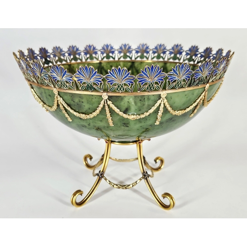 A Magnificent 15K Solid Gold, Nephrite Jade, Diamond and Plique-&agrave;-Jour Enamel Russian Style Bowl by Simon Rudle. The large 20th century bowl features a finely carved nephrite jade body applied with laurel garlands suspended from a reeded 15K solid gold ring and raised on a solid gold stand. The top is set with thistle-shaped plique-&agrave;-jour enamel, with platinum junctions set with diamonds to the stand. Laser tested as 15K gold, with approximately 300+ grams of gold. Signed Rudle. Nephrite jade in excellent condition. Size approx: 18cm height x 25.5cm width. Impressive total weight: 1060g. Winning bidder must collect from Cadmore HQ or arrange a courier. *Simon Rudle was a Russian-born jeweller from Odessa, Ukraine, later working in New York from the 1970s to 2000s. He came from a distinguished jewellery family and was known for Faberg&eacute;-style craftsmanship, producing bespoke pieces for wealthy clients. Rudle worked with prestigious houses including Bulgari, David Webb, Tiffany & Co. and Van Cleef & Arpels before opening his own workshop in 1978. His work pays homage to master jeweller Carl Peter Faberg&eacute;.