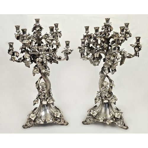 A Large Pair of Italian Buccellati Style Solid Silver Candelabra. Beautifully designed as tree-form candelabra with detailed branches, hanging leaves and grape decoration. Each piece features a seated cherub, one male cherub holding a basket of grapes and one female cherub eating a single grape. Both are hallmarked &ldquo;800&rdquo; with further marks to the base. Very good condition. Approx 80cm height. Total weight: 8.6kg. Winning bidder must collect from Cadmore HQ or arrange a courier.
