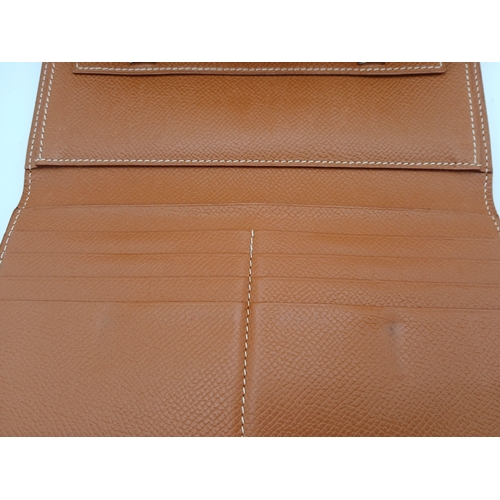 19 - An Hermès Tan Epsom Leather Kelly Long Wallet. Tan Epsom leather exterior with silver-toned hardware... 