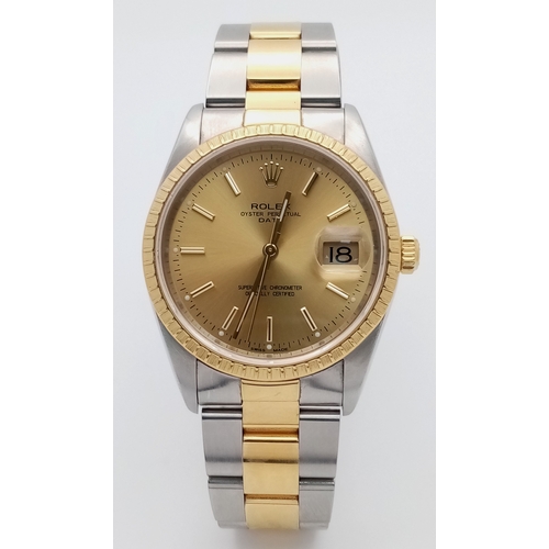 A Bi-Metal Rolex Oyster Perpetual Date Watch. Model M15223. 18K Gold and stainless steel bracelet and case - 36mm. Gold tone dial with date window. Fluted gold bezel. In working order. Comes with box and papers including a Watch register and WCSA report. Ref: 028213.