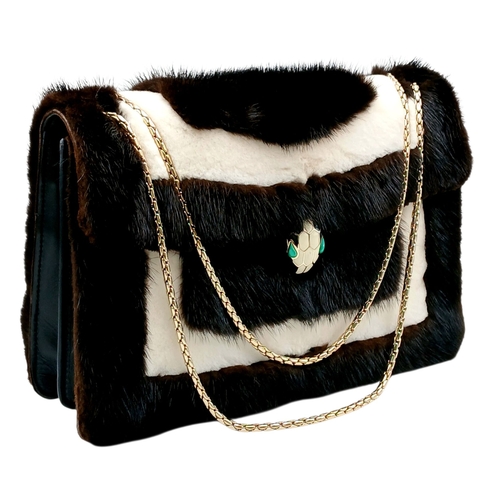 A Bvlgari Serpenti Fur and Leather Shoulder Bag. Contrasting black and cream fur exterior with smooth black leather trim, gold-tone hardware, signature Serpenti snake head closure with enamel detailing and a gold-tone chain shoulder strap. Flap closure opens to a vibrant turquoise leather interior with two main compartments divided by a central zipped compartment, two open inner side pockets and one zipped inner side pocket. Comes with dust cover bag and Bvlgari hand mirror. Approx. 28cm length x 18cm height. In good overall condition with light signs of use - Please see photos or request a condition report. Ref: 12907.