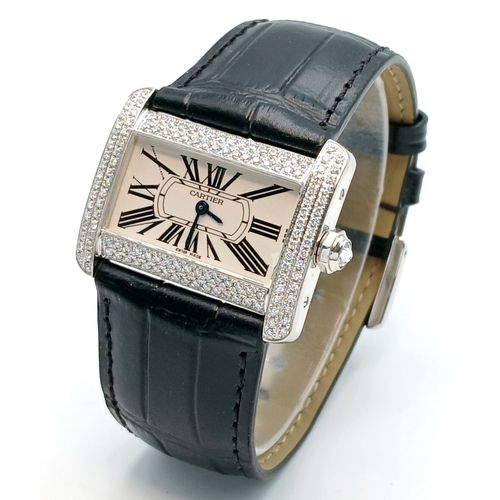 A Cartier Tank Divan Diamond Quartz Ladies Watch. Model 2599. Black leather strap. Stainless steel case - 32mm x 25mm. White dial with Roman Numerals. Two row diamond encrusted outer case. In working order. Note: The outer case diamonds have been professionally custom fitted with natural diamonds.