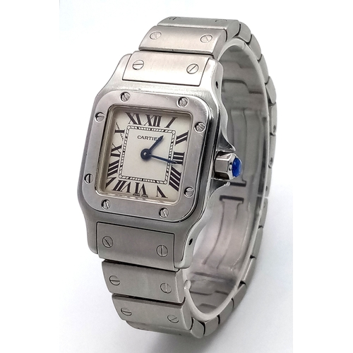 A Cartier Santos Galbee Quartz Ladies Watch. Model 1565. Stainless steel bracelet and case - 24 x 35mm. White dial with Roman numerals. Blue sapphire tipped crown. In working order. Comes with spare links, box and papers. Ref: 029787.