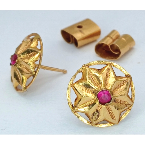 30 - A Pair of 18K Yellow Gold (tests as) and Ruby Floral Form Stud Earrings. 1.6g total weight.