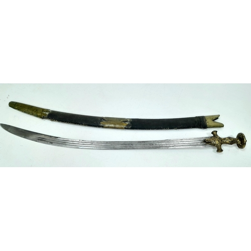 An Antique (circa 1800) Indian Tulwar Curved Sword - Typical of the Mughal Period. A curved single edged blade with multiple grooves (fullers) - 80cm blade length. A distinctive metal hilt with a disk-shaped pommel. Gilded floral Koftgari decoration throughout the hilt. Wood and leather stitched scabbard with brass mounts. 98cm total length. UK Mainland Shipping Only