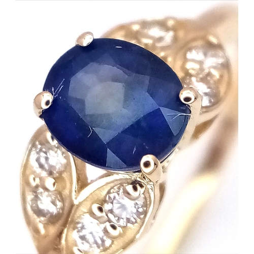 60 - A 14K Yellow Gold Natural Sapphire and Diamond Cocktail Ring. A 1.11ct oval cut sapphire with diamon... 