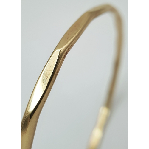 23 - A 9K Yellow Gold Multi-Faceted Gold Bangle. 4mm width. 63mm inner diameter. 15.75g