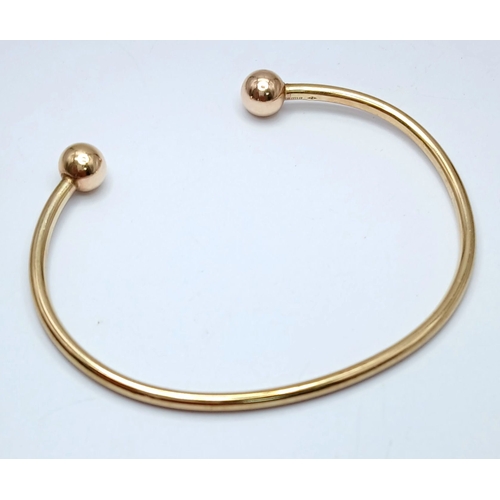 29 - A 9K Yellow Gold Torque Bangle. Bulbous ends. 4g.