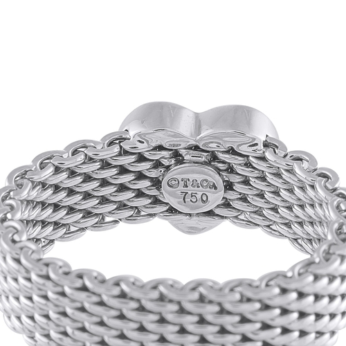 624 - A Tiffany & Co. 18K White Gold Diamond Heart Ring. The mesh band is paired with a heart shaped motif... 