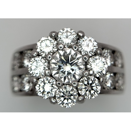 687 - An 18K White Gold and Diamond Dress Ring. A 0.75ct round brilliant cut diamond centre stone with a 2... 