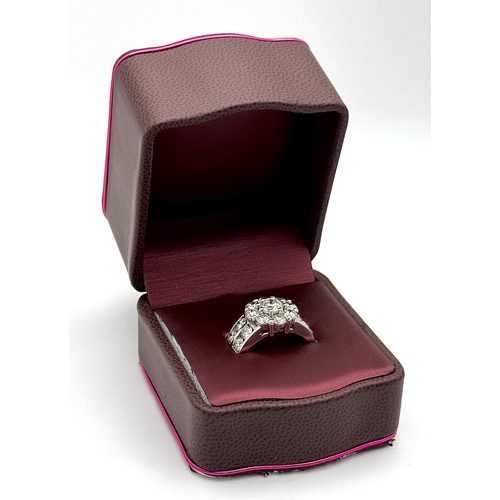 687 - An 18K White Gold and Diamond Dress Ring. A 0.75ct round brilliant cut diamond centre stone with a 2... 