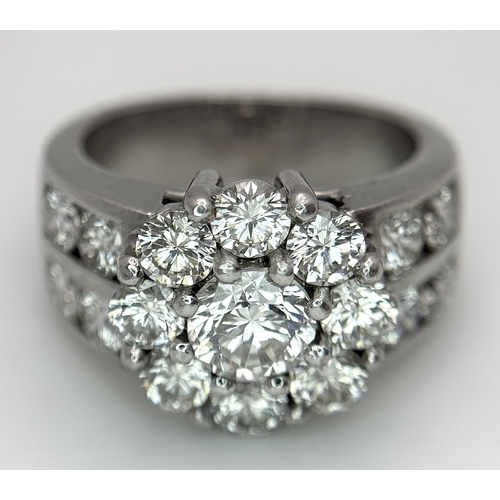 687 - An 18K White Gold and Diamond Dress Ring. A 0.75ct round brilliant cut diamond centre stone with a 2... 