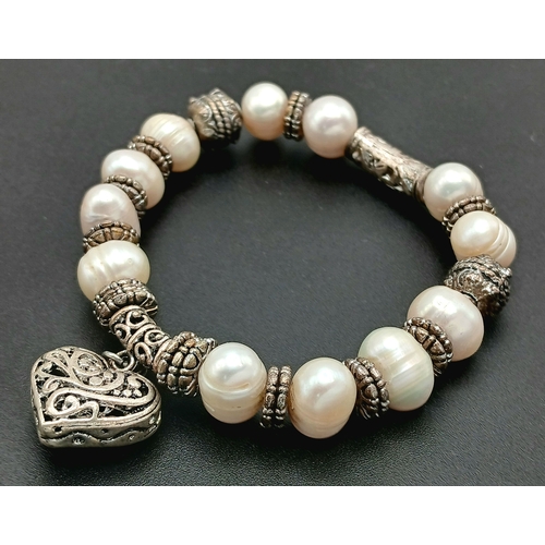 25 - A Pretty Freshwater Pearl and Silver-Tone Heart Charm Bracelet. Set with irregular shaped freshwater... 