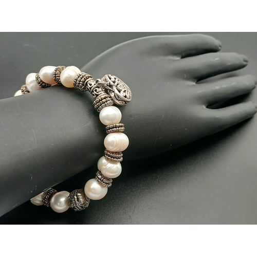 25 - A Pretty Freshwater Pearl and Silver-Tone Heart Charm Bracelet. Set with irregular shaped freshwater... 