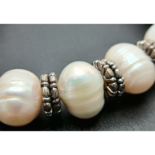 25 - A Pretty Freshwater Pearl and Silver-Tone Heart Charm Bracelet. Set with irregular shaped freshwater... 