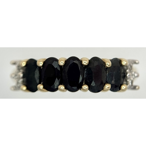 32 - A 9K Yellow Gold Sapphire and Diamond Ring. Five oval cut sapphires with diamond accents either end.... 