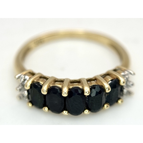 32 - A 9K Yellow Gold Sapphire and Diamond Ring. Five oval cut sapphires with diamond accents either end.... 