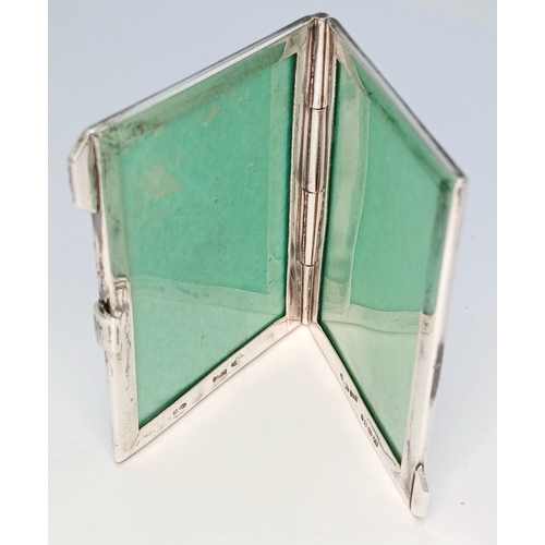 7 - A Hallmarked Sterling Silver Double Photograph Frame Pendant. The rectangular frame has an engine-tu... 