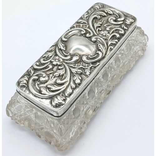 6 - An Edwardian Sterling Silver Mounted Cut Glass Trinket Box. The rectangular cut glass box with a rem... 