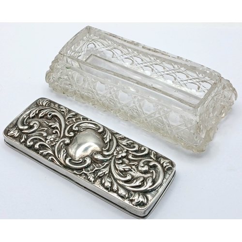 6 - An Edwardian Sterling Silver Mounted Cut Glass Trinket Box. The rectangular cut glass box with a rem... 