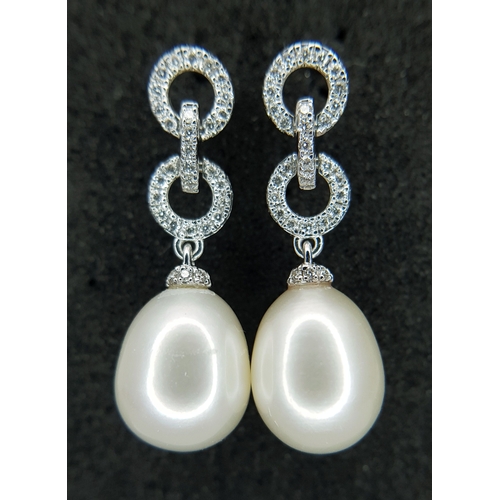 373 - A Pair of 18K White Gold, Pearl and Diamond Drop Earrings. 8mm pear shaped pearls with diamond set c... 