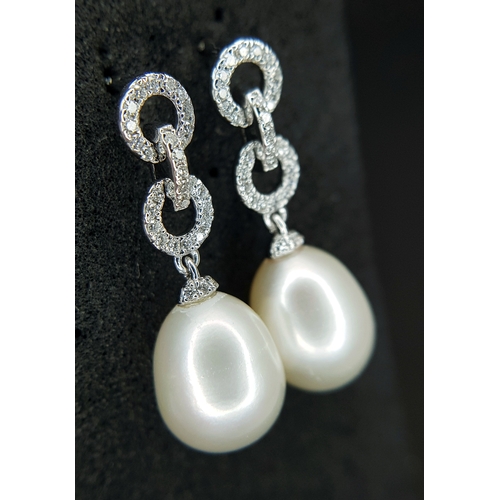 373 - A Pair of 18K White Gold, Pearl and Diamond Drop Earrings. 8mm pear shaped pearls with diamond set c... 