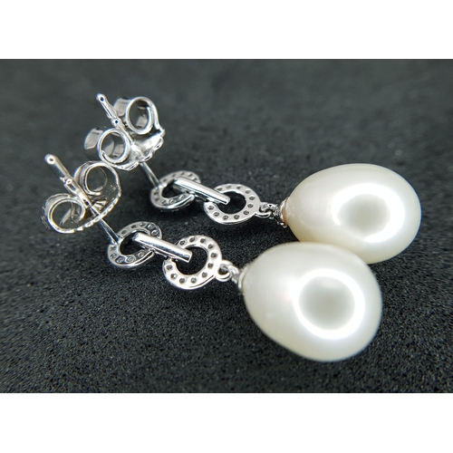 373 - A Pair of 18K White Gold, Pearl and Diamond Drop Earrings. 8mm pear shaped pearls with diamond set c... 